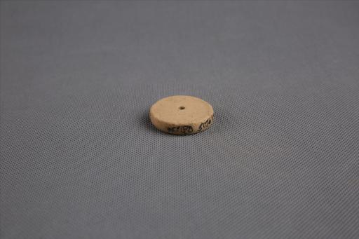 商圆饼形中穿夹砂黄褐陶纺轮