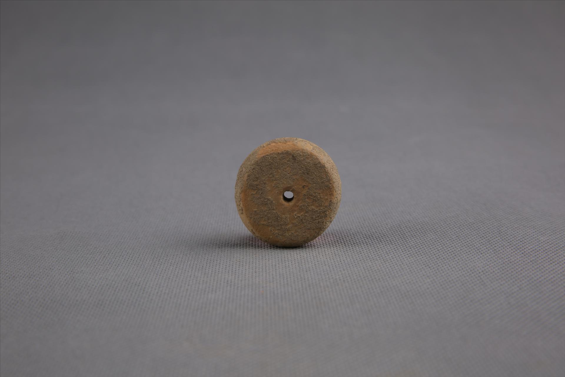 商圆饼形中穿夹砂黄褐陶纺轮
