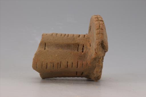 新石器时代大溪文化猪嘴形弧顶宽缘刻划短条纹夹砂红陶支座