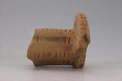 新石器时代大溪文化猪嘴形弧顶宽缘刻划短条纹夹砂红陶支座