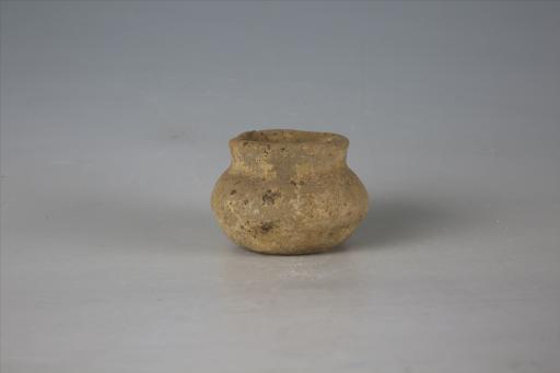 东汉小敞口扁鼓腹平底泥质灰黄陶罐