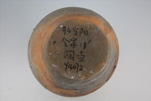 东汉束颈弧腹平底双耳凸棱纹夹砂红褐陶壶