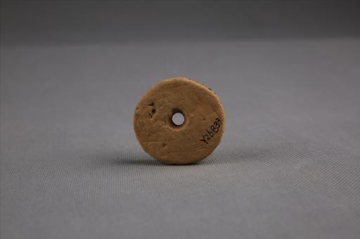 商圆饼形中穿戳印点纹刻划斜线纹夹砂红褐陶纺轮
