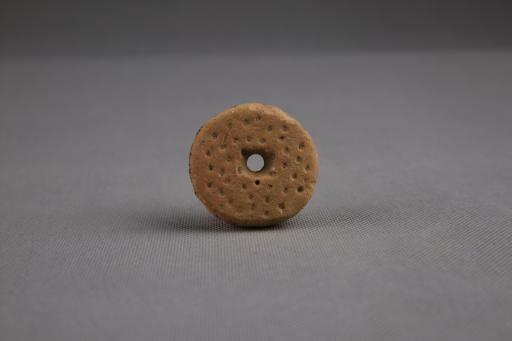商圆饼形中穿戳印点纹刻划斜线纹夹砂红褐陶纺轮